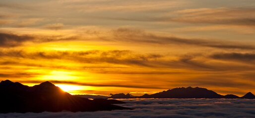 Wunderschöner gelbroter Sonnenaufgang oberhalb der Wolken | © Tauber Gerd