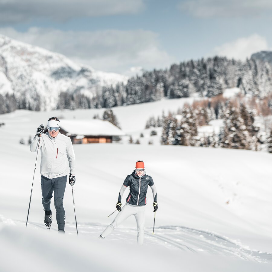 Due sciatori di fondo con un rifugio sullo sfondo | © IDM Südtirol-Alto Adige/Manuel Kottersteger
