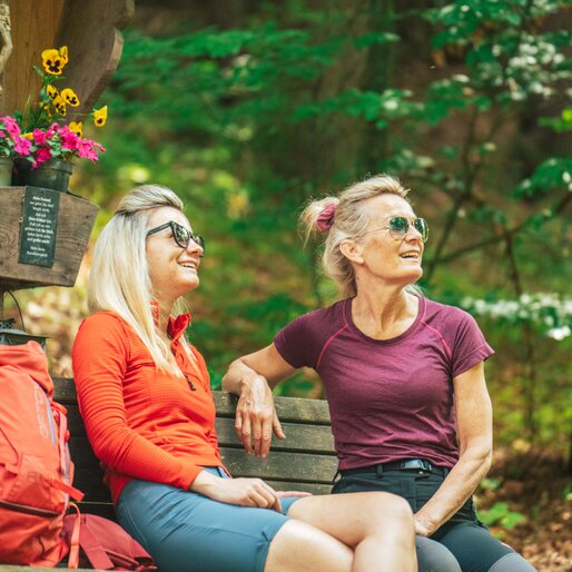 Two hikers resting on a bench | © H.E.R.B. -Media vGmbH