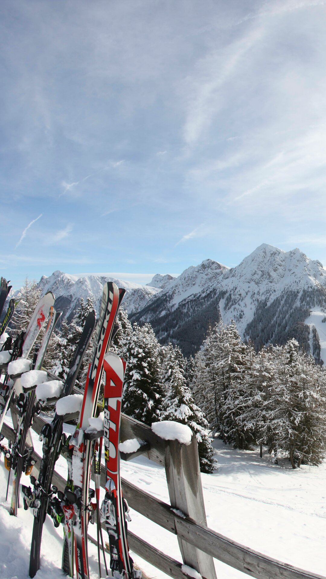 Skis leaning against the fence with mountain panorama | © Ski Kronplatz
