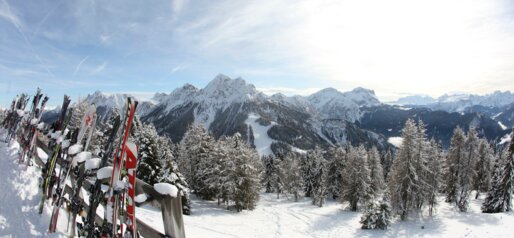 Skis leaning against the fence with mountain panorama | © Ski Kronplatz