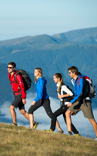 Vier Wanderer nebeneinander auf einem Wanderweg | © Helmuth Rier