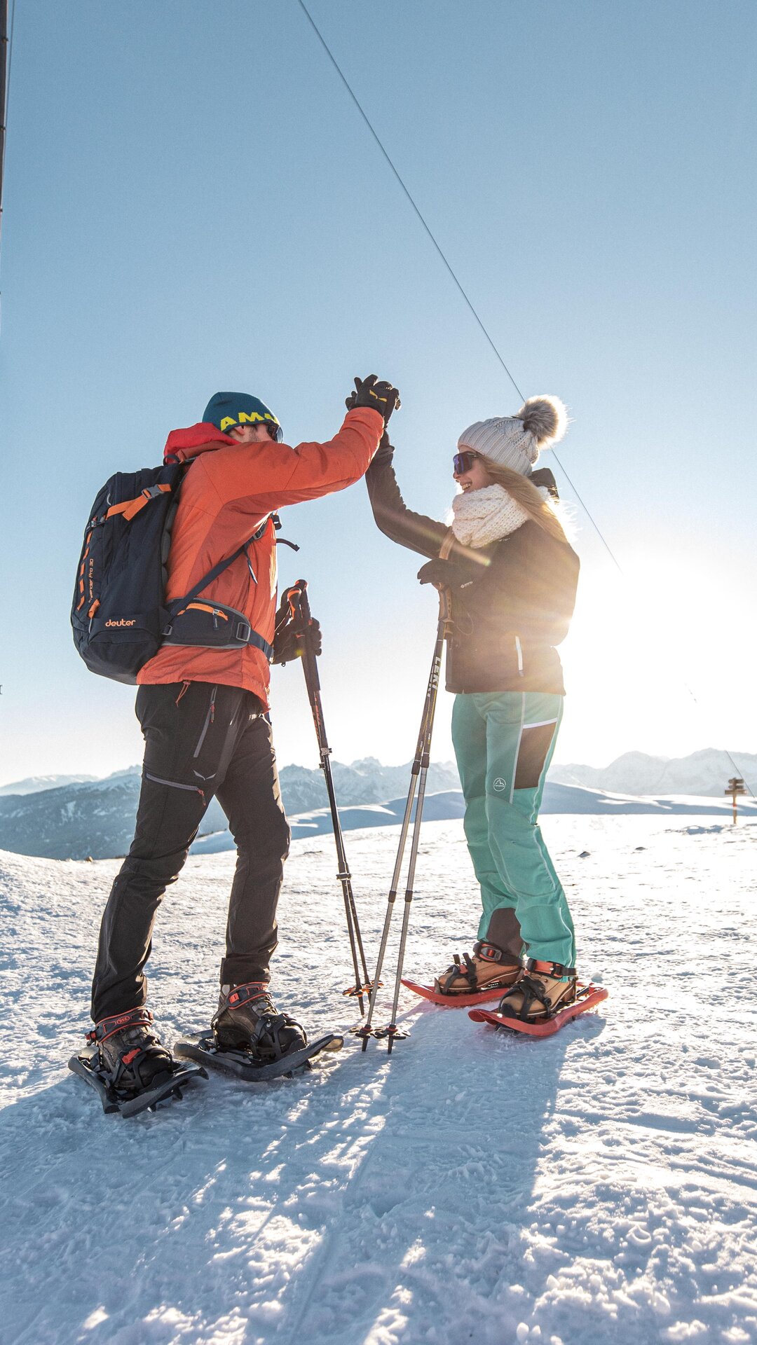Schneeschuhwanderer geben sich High-Five am verschneiten Gipfel