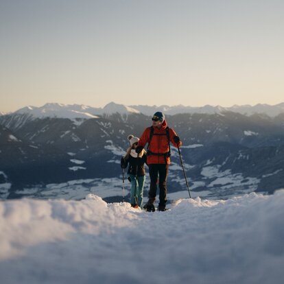 Two snowshoe hikers in front of a mountain panorama  | © Rawmedia